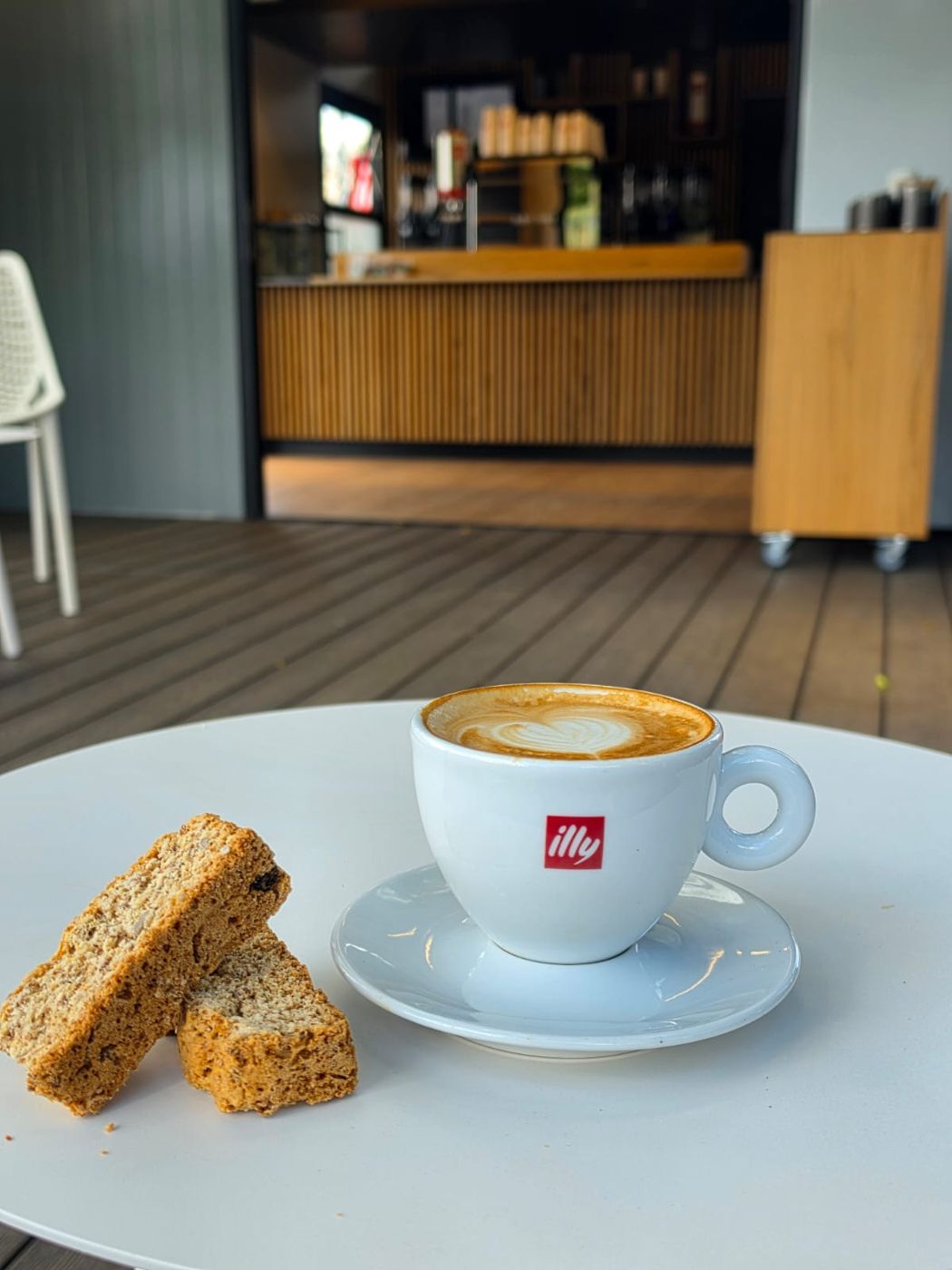 Cappuccino with heart latte art and two rusks on a table at Tiny Town Café
