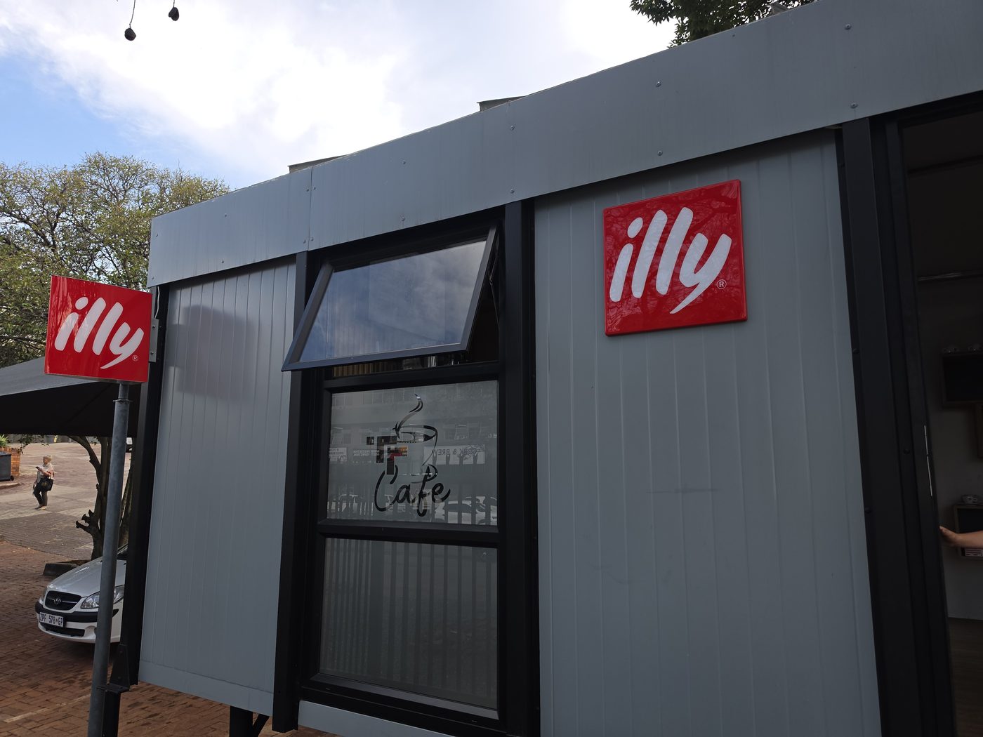 Tiny Town Café modular unit — side view with illy sign