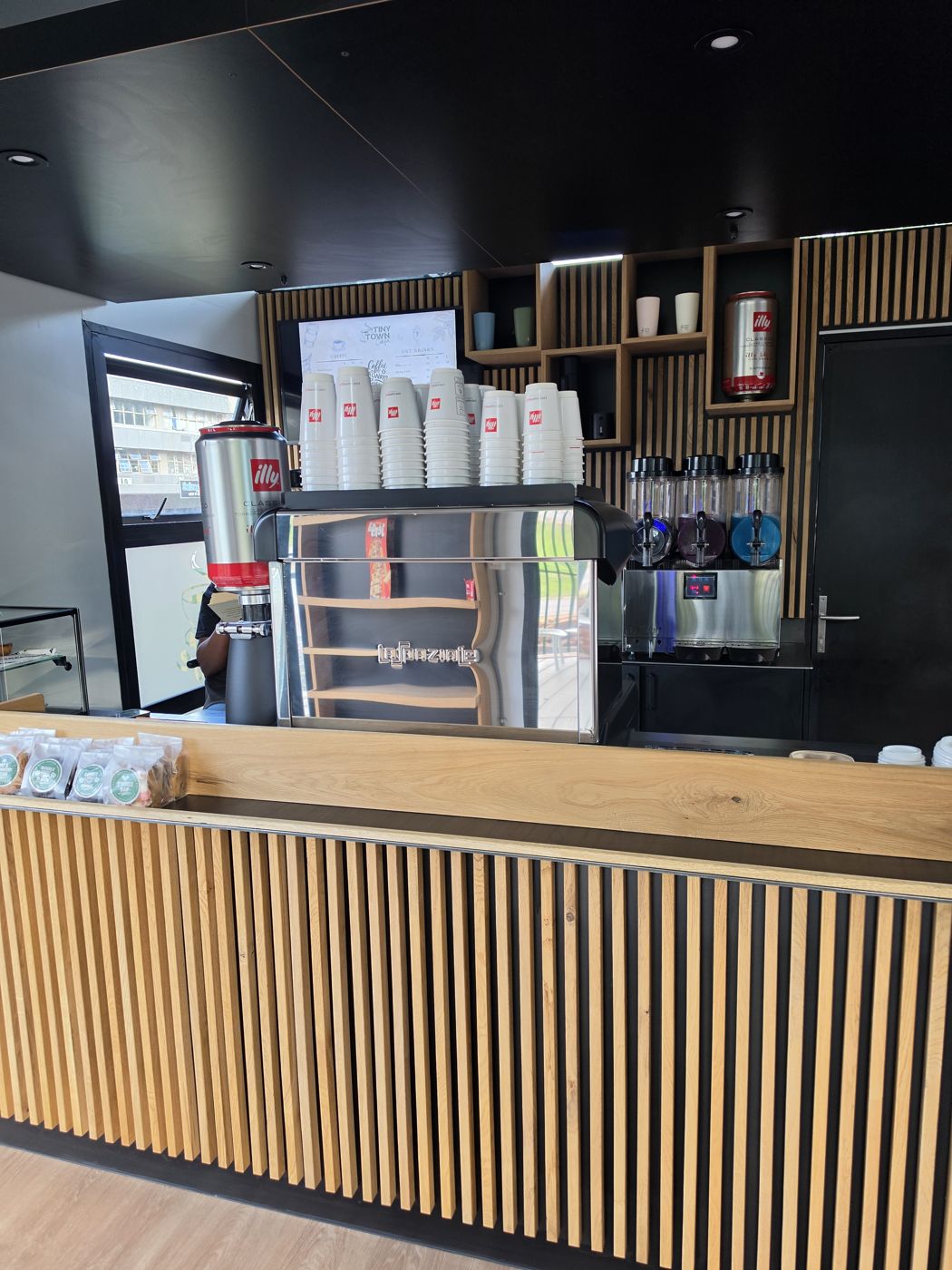 Tiny Town Café interior — La Marzocco espresso bar and wood-slat counter